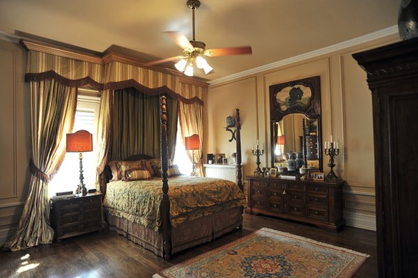 A partial view of the comfortable and luxe master suite with its handsome curtain and canopy configuration.