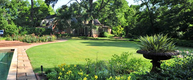Sweeping vistas, such as this view looking across the sunny lawn to the rear of the home, are important features of this East Memphis garden.
