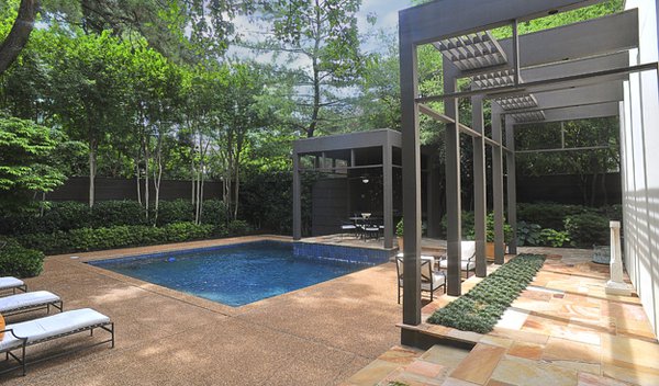 A stone terrace beckons visitors to a refreshing pool, making the Cooley home a true oasis in Central Gardens