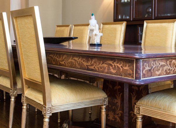 The marquetry work on the dining room table features carved veneer organic patterns inliad into the top and sides.