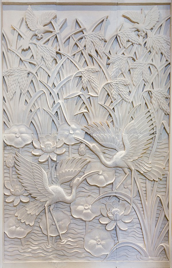 Also hand-carved in Bali by artisan Made, this sandstone wall depicts cranes wading in a pond flecked with lotus flowers.