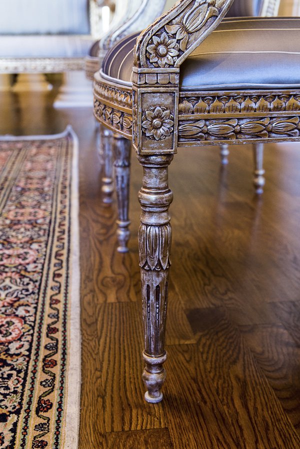 French artisan Jean Phillips spent two years hand-carving the intricate details of theses European-inspired teak chairs. The ornate legs are highlighted with gold leafing.