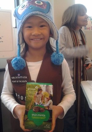 Ami Masler from Holy Rosary Troop 10105 shows off a box of Thin Mints.