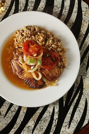 Kingston stew fish is a delicious blend of tilapia, pimentos, peppers and scallions served over rice and pigeon peas.