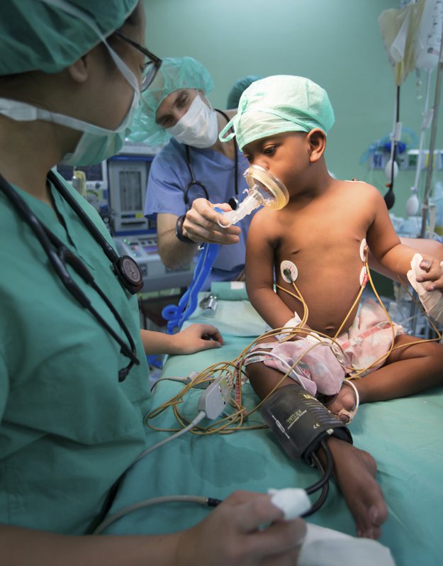 Juan Manuel receives oxygen from Dr. Juan Boriosi before an operation to correct a condition called Tetralogy of Fallot. This defect causes low oxygenation of the blood and bluish coloring. A shunt helped the child receive more blood flow to the lungs.
