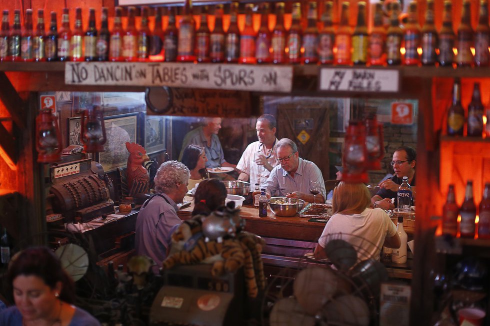 Food, libations, and camaraderie draw folks to the bar as dusk settles over Fat Possum. 