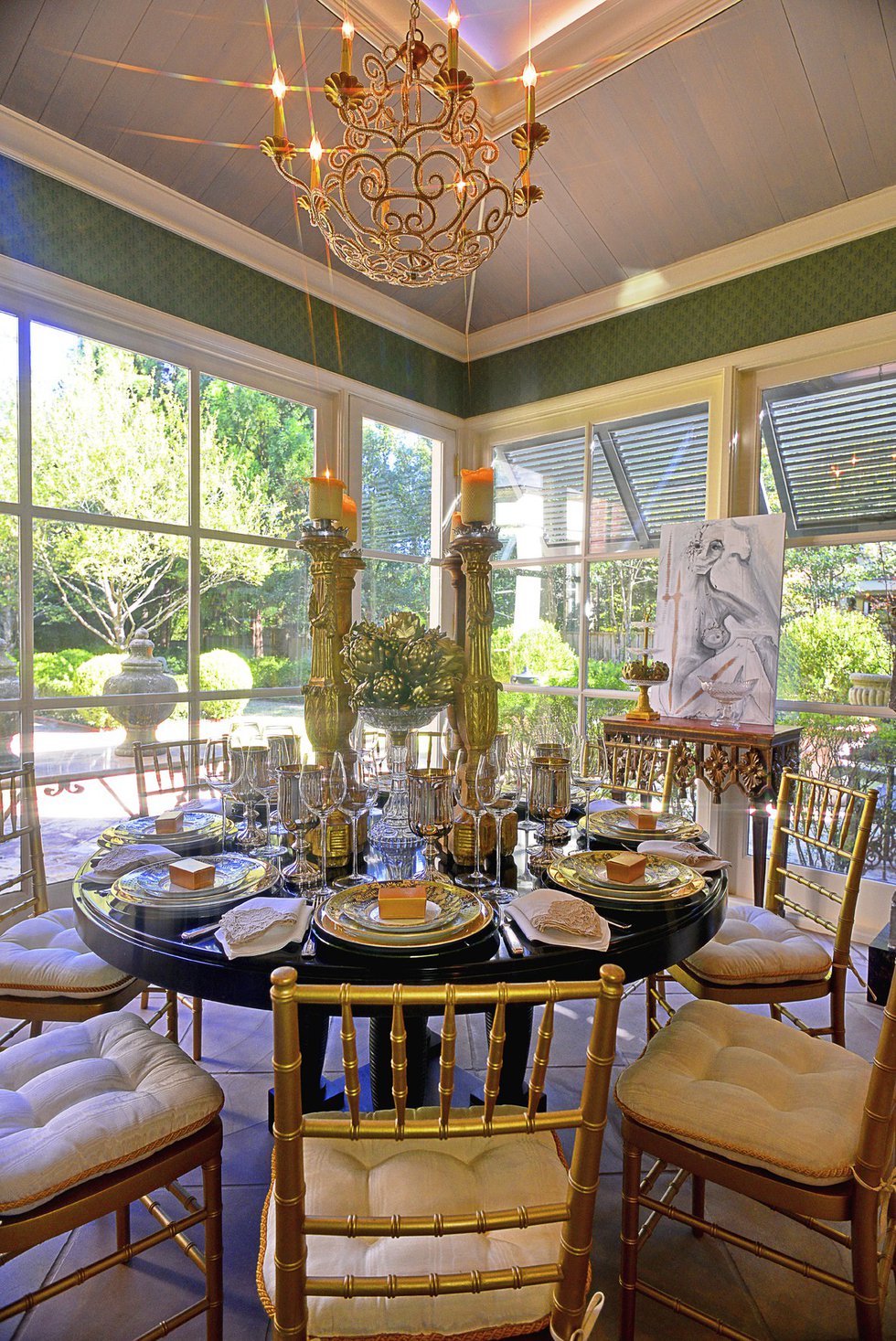 The sunroom with its round table, gold chairs, and glorious views of the formal gardens is the perfect setting for a small, elegant family breakfast.
