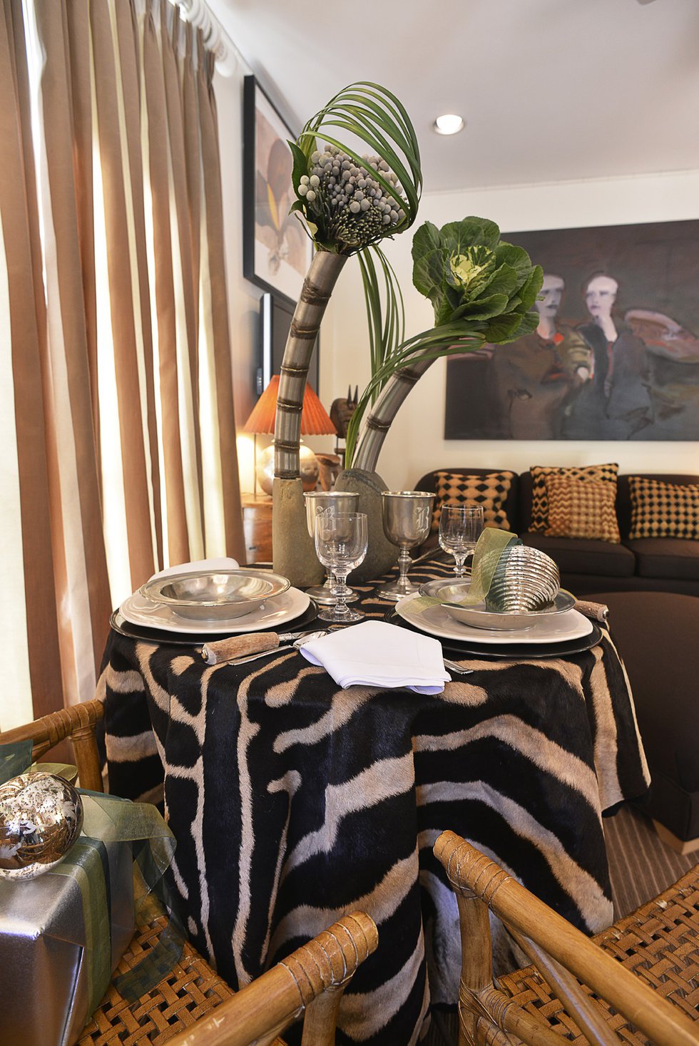 The stunning, very contemporary tablescape in the guest house has an exotic African vibe in keeping with the rattan furniture and zebra rugs.