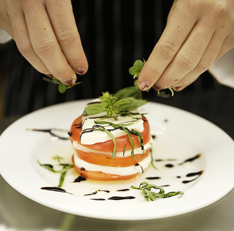  A chiffonade of basil is the finishing touch on the team’s Caprese Tower Salad.
