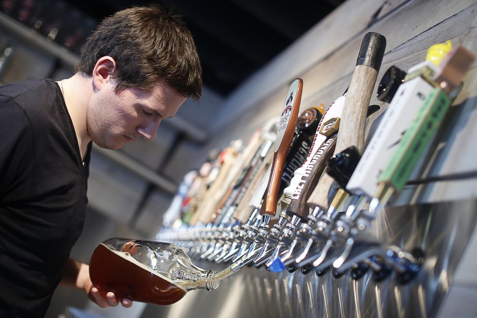 Kevin Eble fills a growler — or small jug — with locally brewed Ghost River beer.