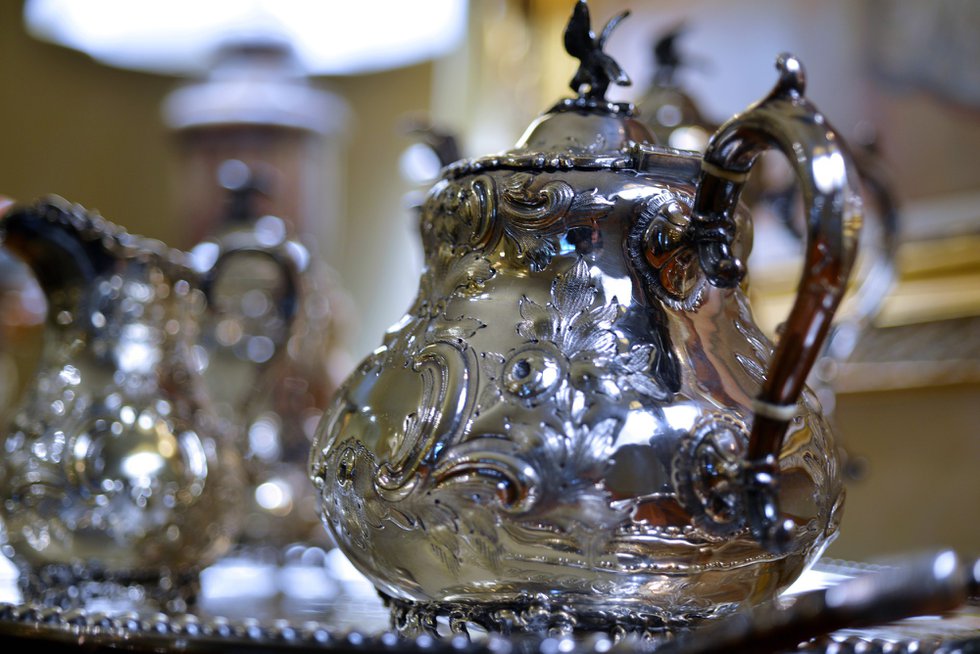 The dining room’s antique rococo silver service glistens on the sideboard. 
