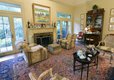  Step down into the living room anchored by a large peach and blue oriental rug, and then step out through French doors to the gracious garden beyond.
