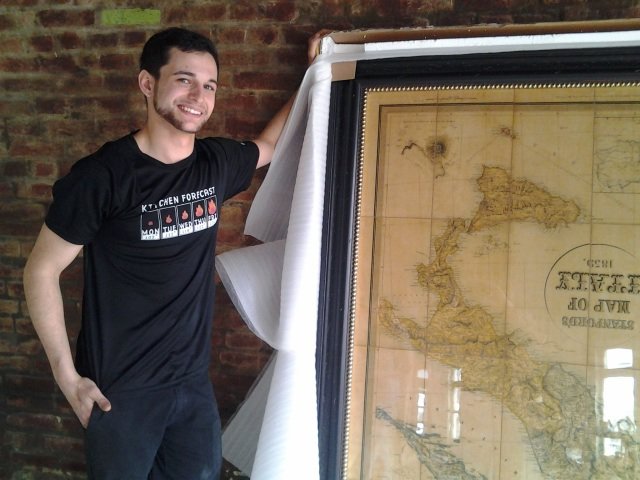 Chef Josh Steiner with a just-unwrapped vintage map of Italy for his new restaurant.