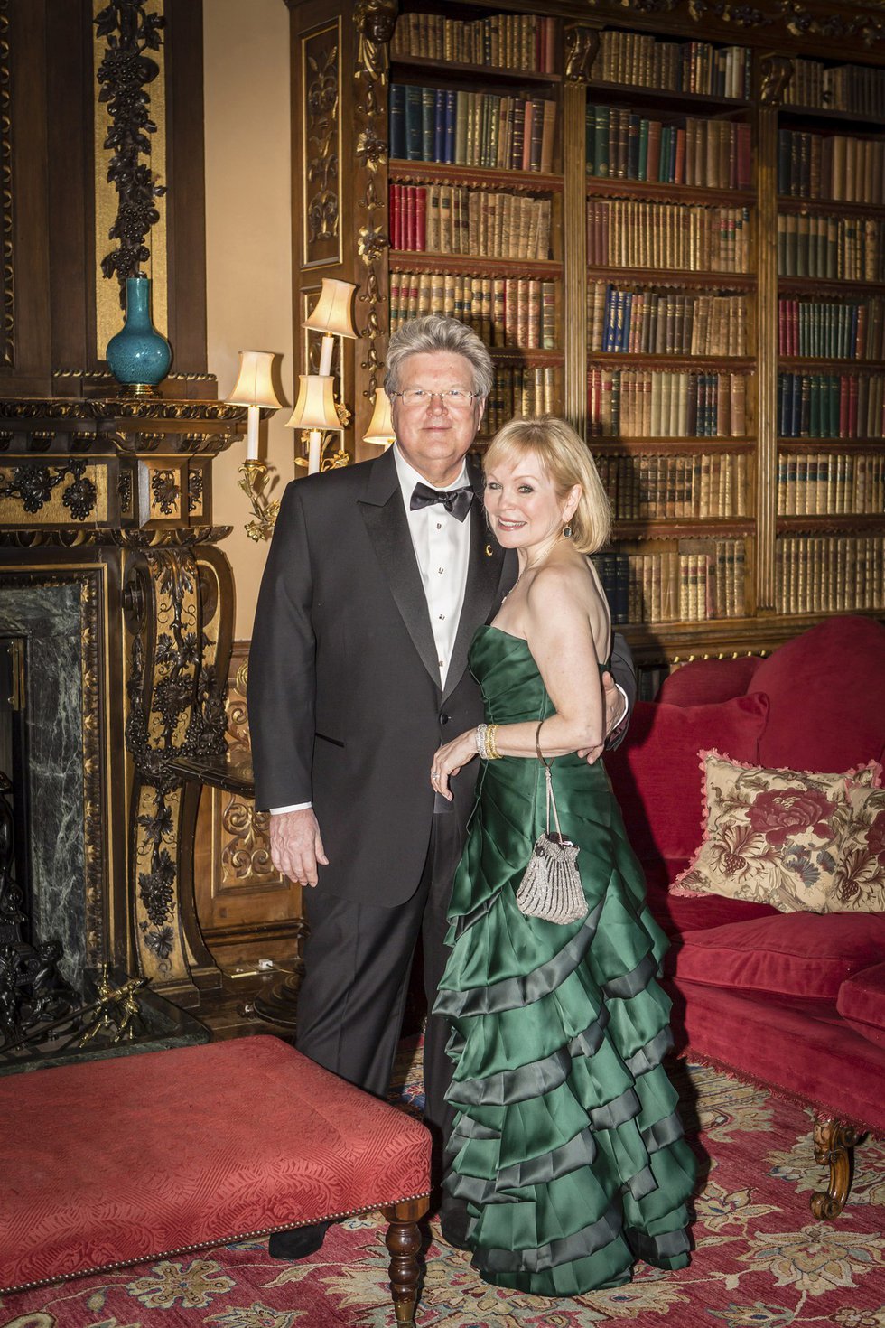 Lord Jeffrey and Lady Mary, the gracious and very glamorous hosts, who are celebrating their 40th wedding anniversary, look every bit their aristocratic parts, as they take time out to pose together in front of the library’s fireplace.