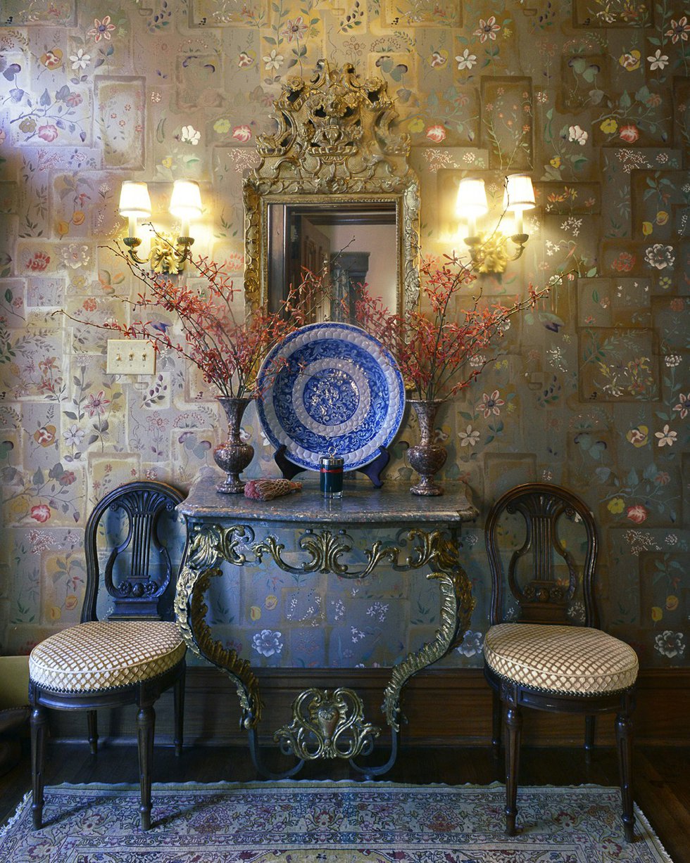 The entryway with its luminous Clarence House wallpaper welcomes visitors and sets just the right elegant tone for what lies within.