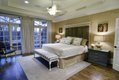 The master bedroom is papered with metallic grasscloth, which gives a glow to the room; the drapes soften the decor and afford a bit of privacy.

