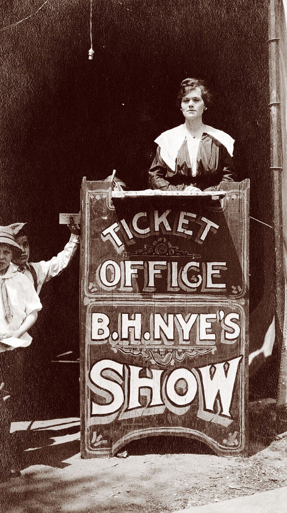 The woman in this 1912 photo, identified as Anna Bennett, is working the “ticket office” for B.H. Nye’s Show — a traveling carnival at East End Park.
