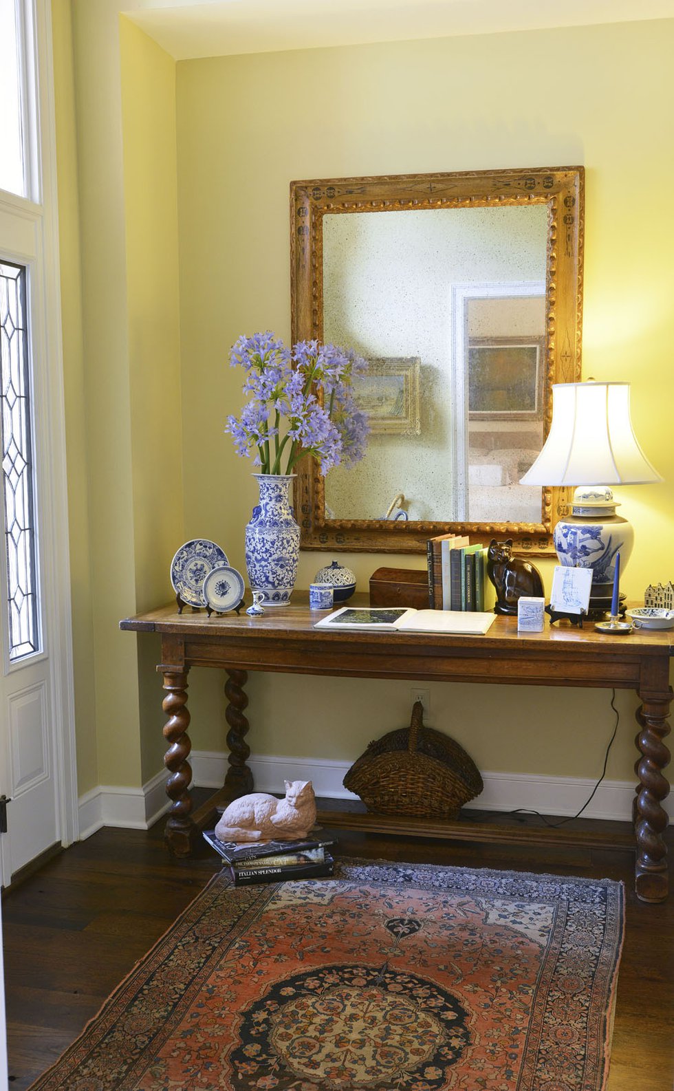 A blue and yellow color scheme and an oriental rug in the home’s elegant entryway offer visitors a warm welcome.