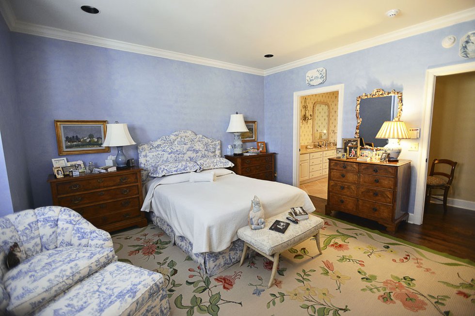 Blue and white toile and a flower-sprigged carpet decorate the master bedroom, which is entered off a little hall especially designed by Cannon.