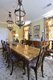 A handsome antique table and massive lantern light fixtures anchor the dining room, which opens onto the living room, a configuration that allows for casual living and comfortable entertaining.