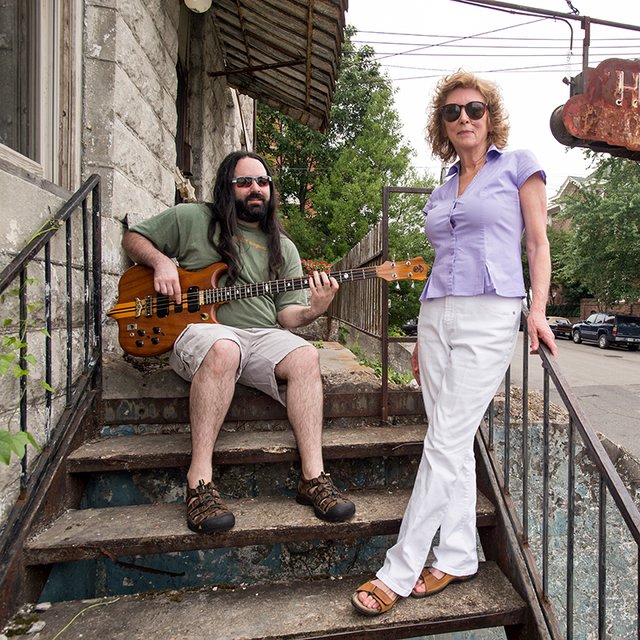 Jamie and Leigh Davis relax on the front porch of the old hotel that has served as their home. 
